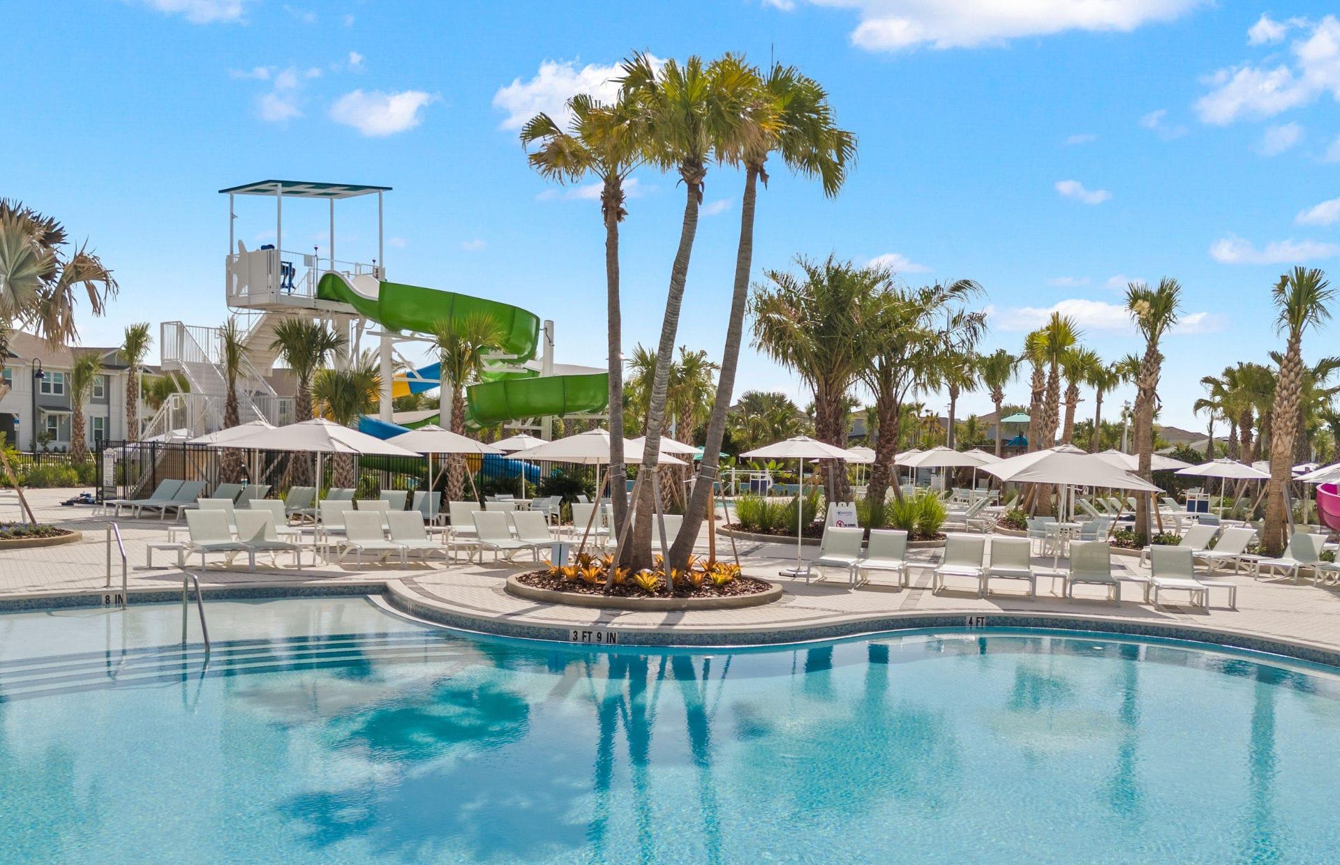Piscina resort com torre de toboáguas e palmeiras